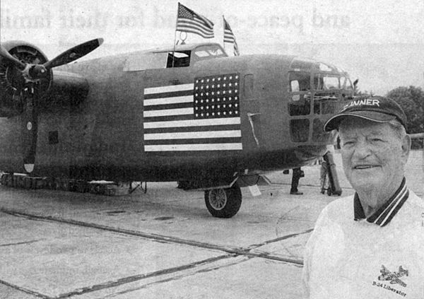 Larry Hilte stands before a B-24 in 2012